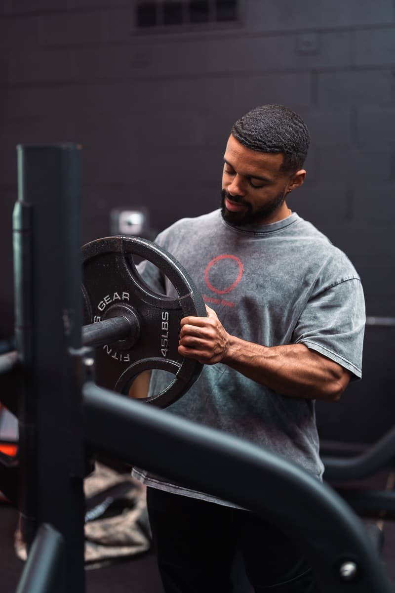 Athlete loading a plate while wearing Eternal Pump
